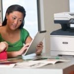 Xerox® VersaLink® B415 Multifunction Printer in the workplace Two women using a tablet in front of a Xerox® VersaLink® B415 Multifunction Printer