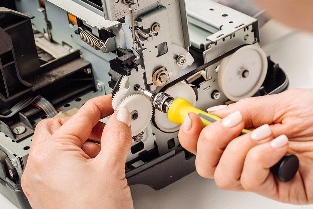 Engineer diagnosing and repairing a photocopier fault